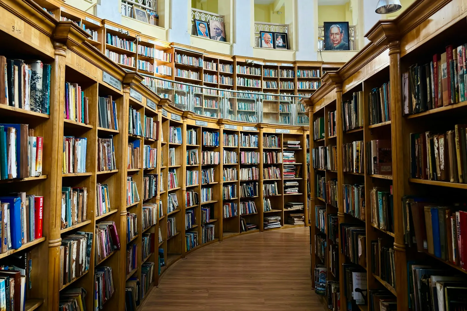 Long curved rows of wooden library bookshelves filled with books