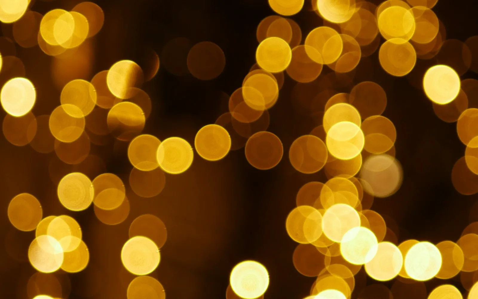 Golden circular bokeh lights scattered against a dark background