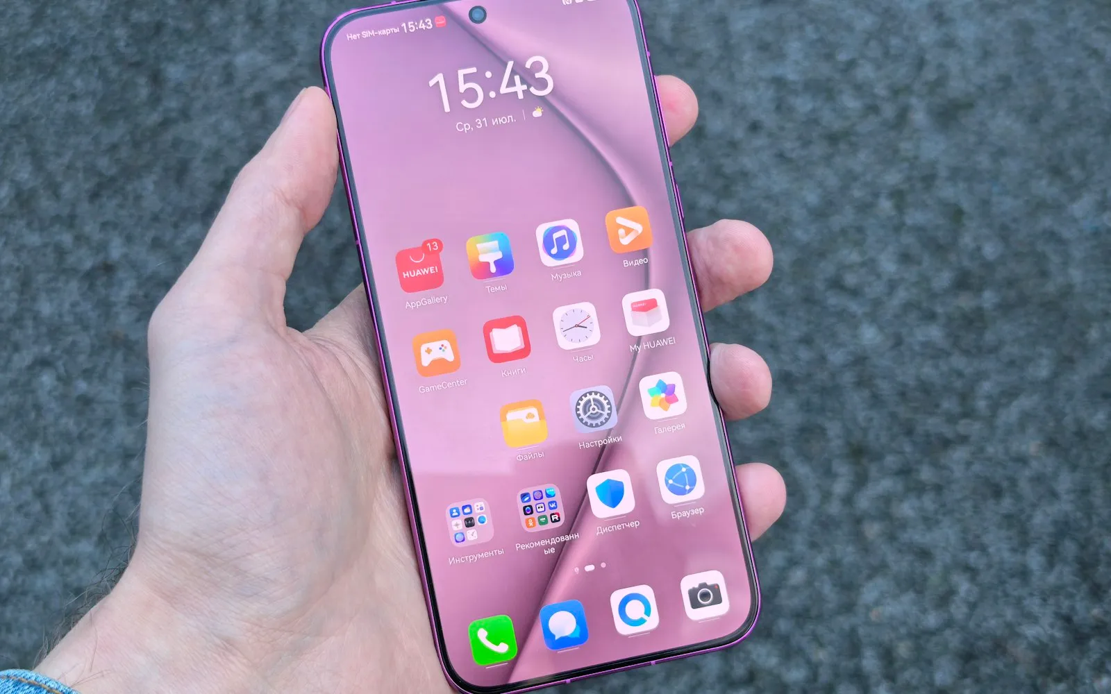 A hand holding a smartphone showing a home screen full of colourful app icons