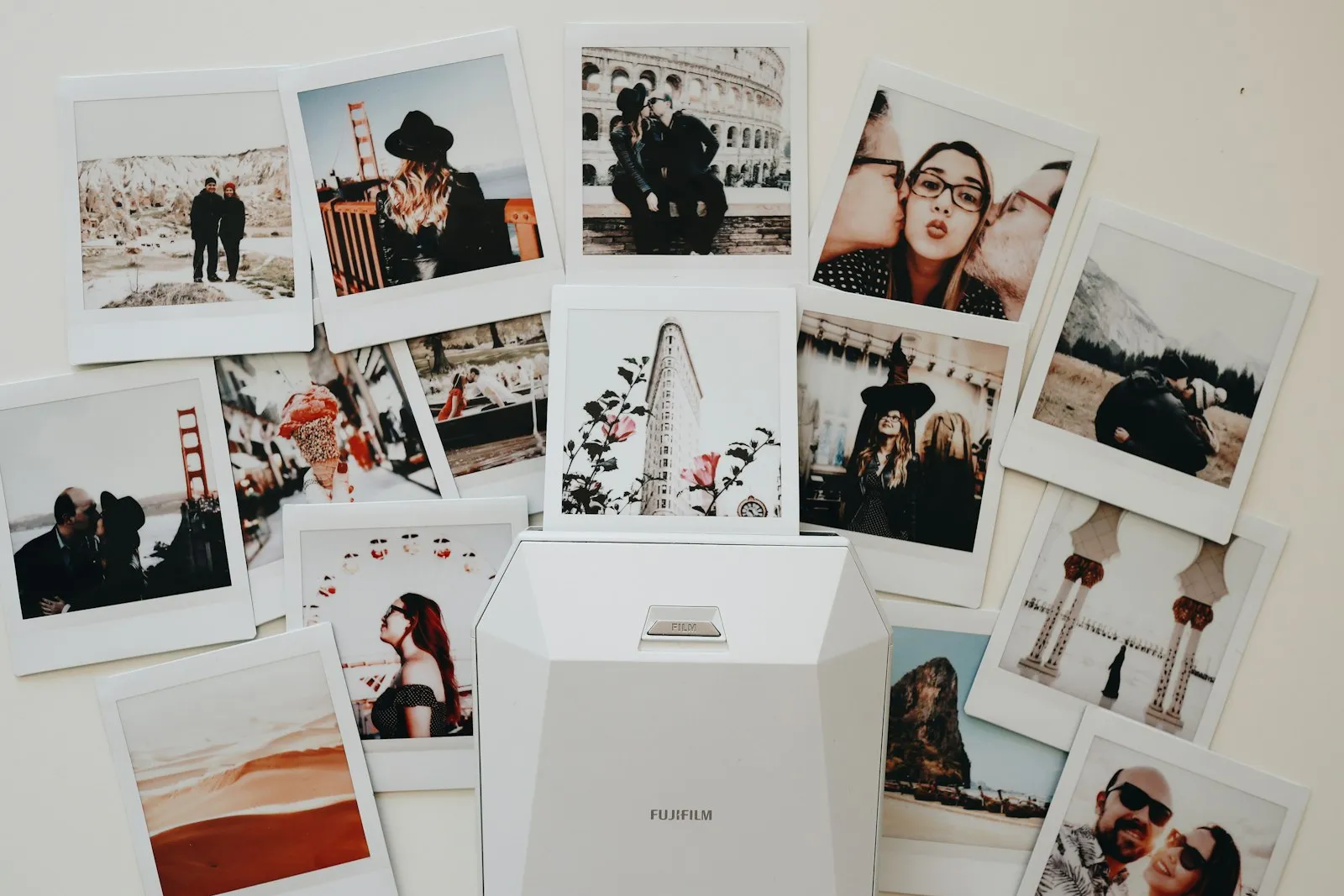 A collage of instant photos and prints pinned to a white wall