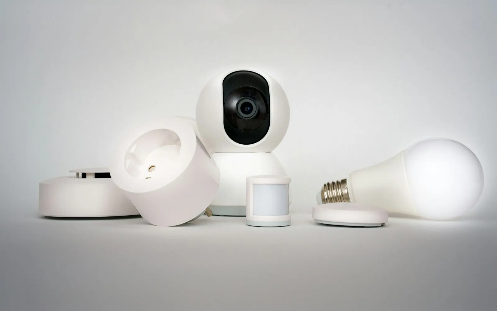 White smart-home devices including a camera, a smart plug, a motion sensor and a light bulb